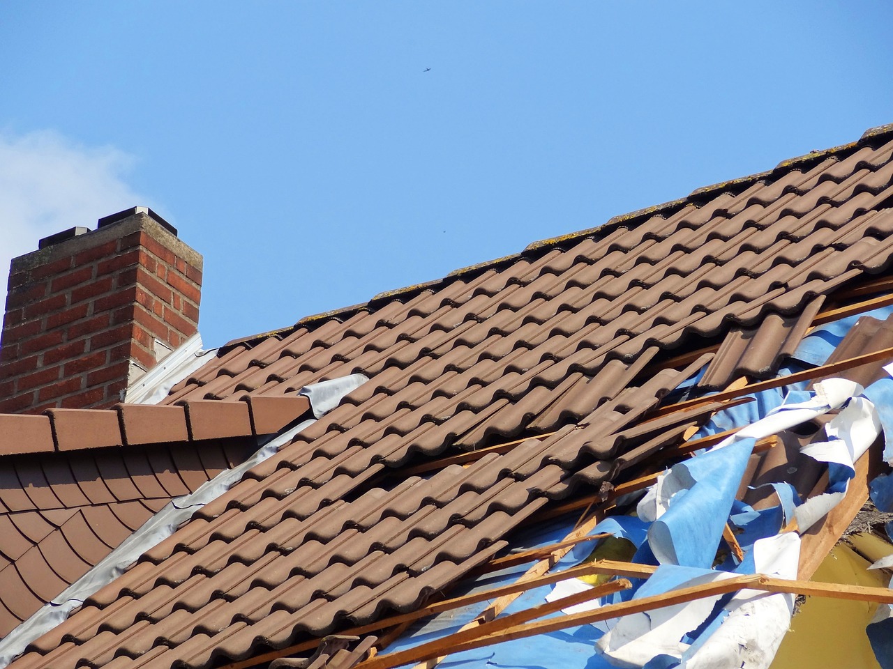 Image of a damaged roof, representing the risks and consequences of improper property insurance coverage.